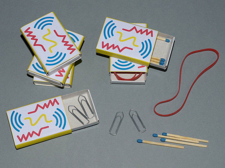 Matchboxes with colourful sleeves containing little objects for playing a sound memory game, photo: Julia Marquardt